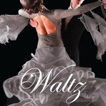 A ballroom dance couple performing a waltz, shown from behind the woman who wears an elegant gray embellished gown with an open back and a flowing white ruffled skirt. Her partner, partially visible, wears a black suit as they hold each other in a classic dance frame against a dark background.