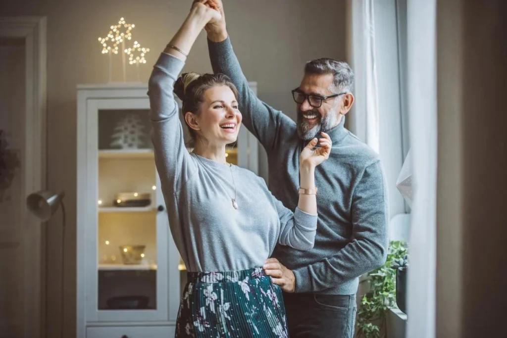 Couple reconnecting during ballroom dance lesson in The Woodlands TX smiling and laughing together